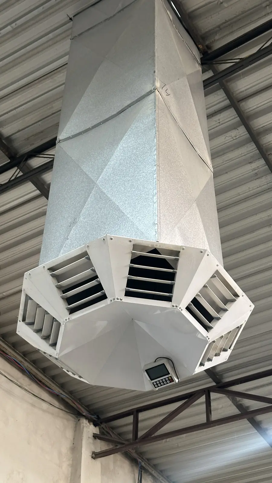 Difusor de teto octogonal ligado a duto metálico, distribuindo o ar climatizado